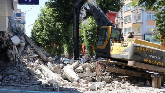 Depremden hasar gören bina yıkılırken yan binada çatlak oluştu, bina tahliye edildi