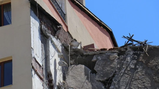 Depremden hasar gören bina yıkılırken yan binada çatlak oluştu, bina tahliye edildi