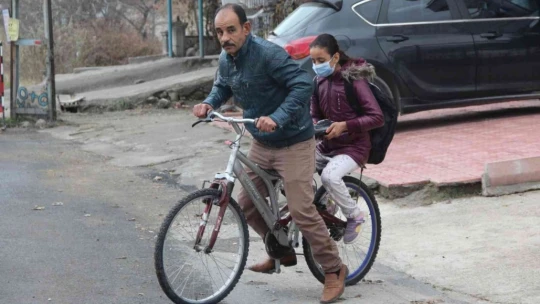 Fedakar baba, yürüyemeyen kızını 4 kilometre uzaklıktaki okula bisikletiyle götürüyor