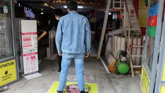 Müşteriler Macron'un fotoğrafına basıp geçiyor