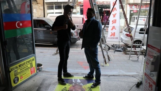 Müşteriler Macron'un fotoğrafına basıp geçiyor