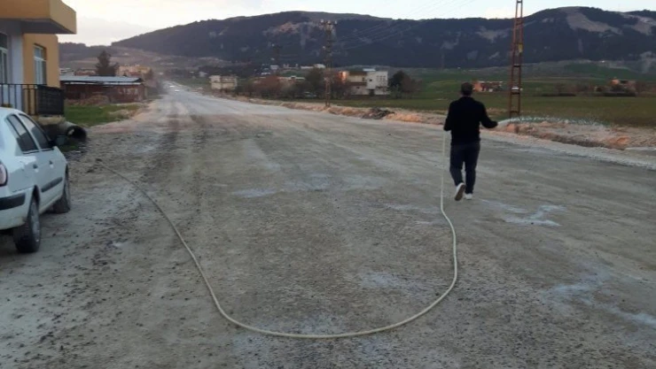 Yolda oluşan toza vatandaşlar su ile müdahale ediyor